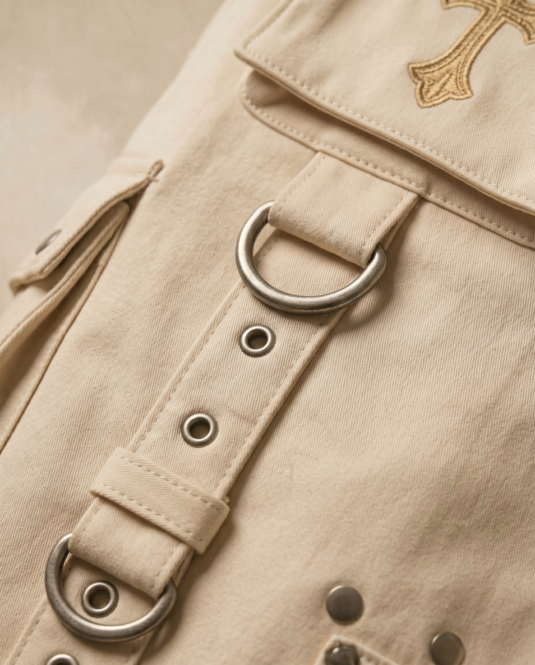 Actively Rich Ascension Noir ivory cream cargo pants detail of utility strap and metal ring hardware highlighting luxury streetwear construction.
